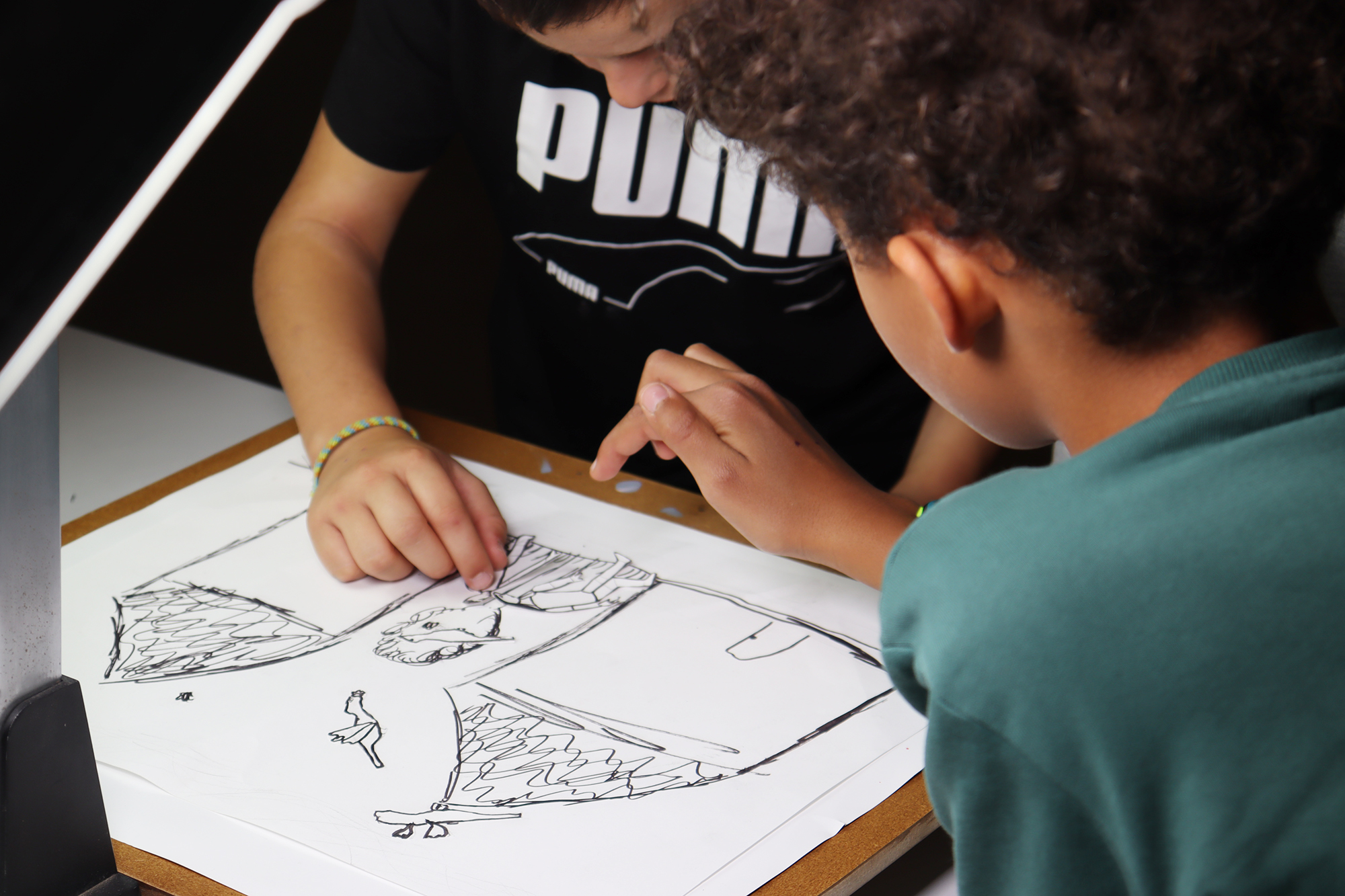 Atelier maison image - enfant qui regarde un dessin - Ville d'Aubenas