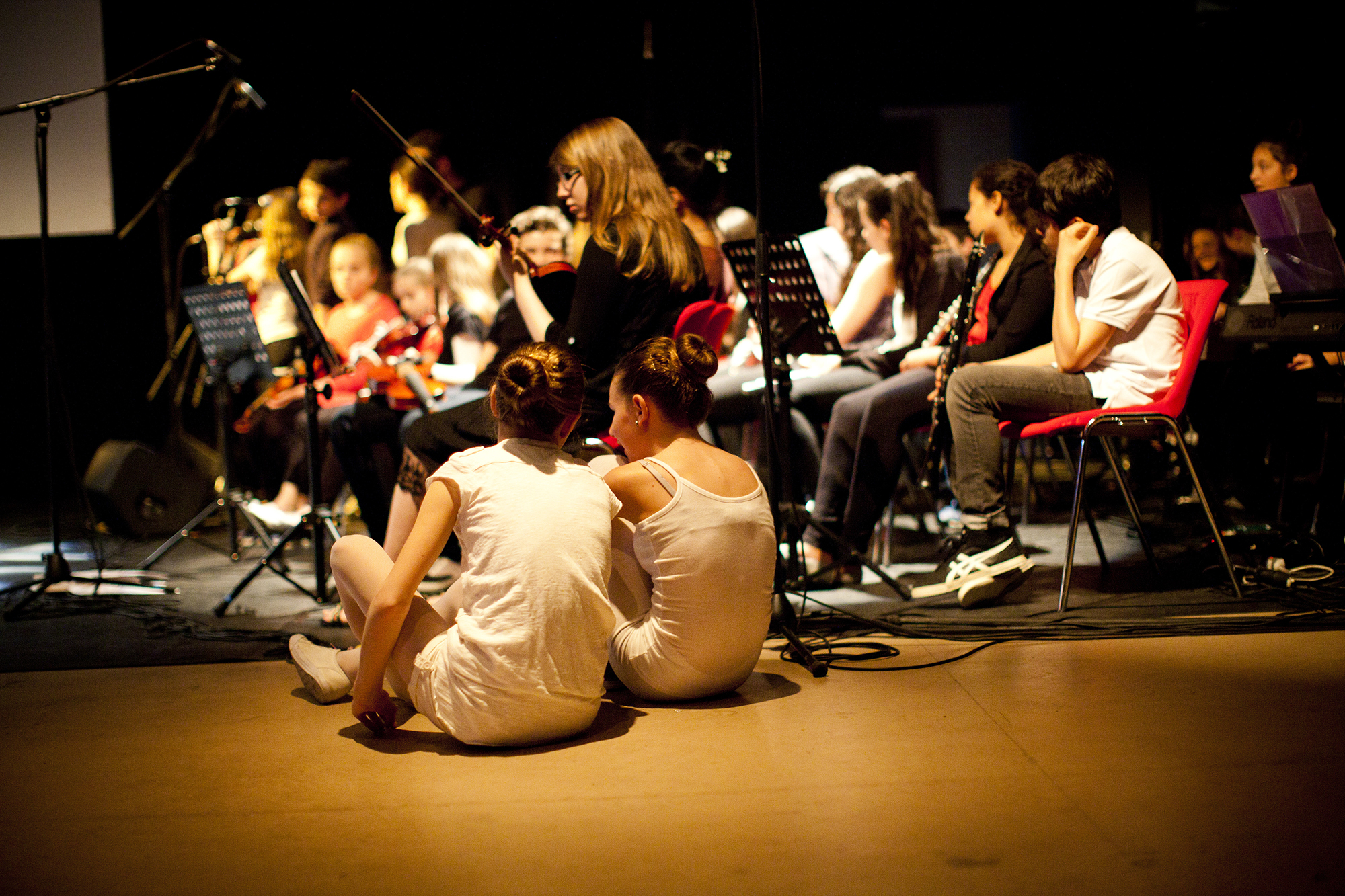 Enfant danseuses assises devant un orchestre